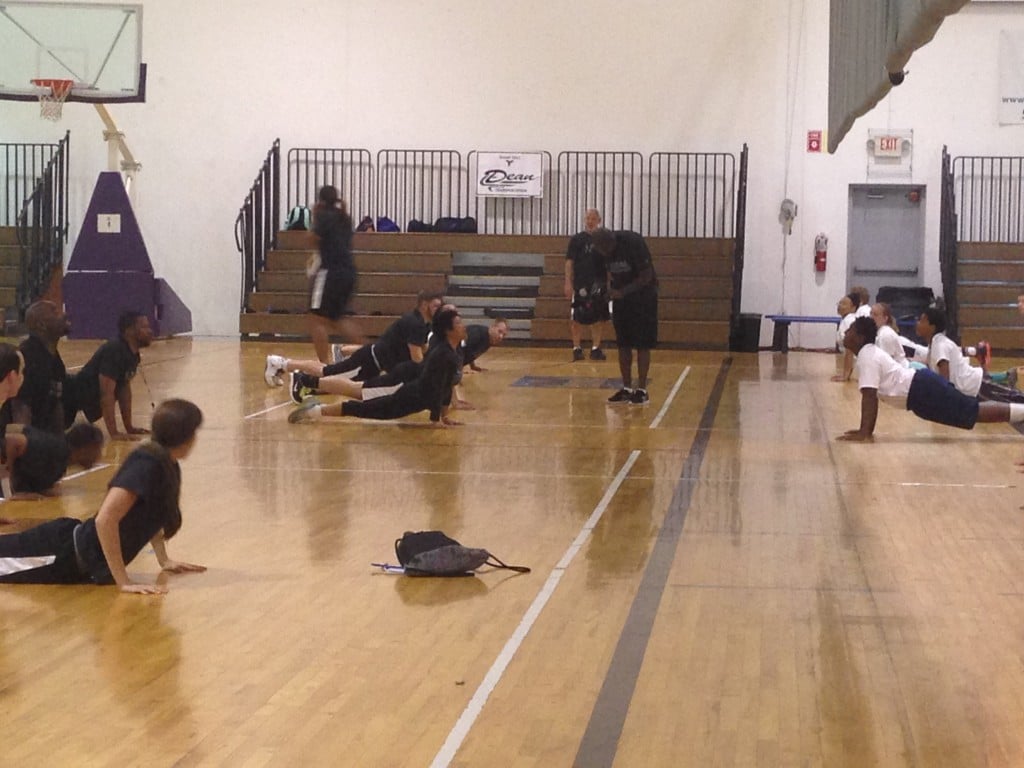 Players doing sun salutations at the Mateen Cleaves 1 Goal 1 Passion Basketball Camp in Lansing.